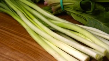 Ispanak, rezene, maydanoz ve yeşil soğan yaprakları tahta kesme tahtasının üzerinde.