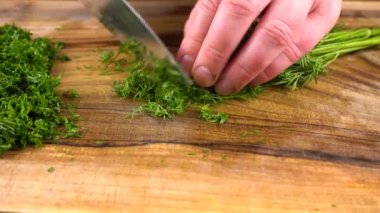 Aşçı, tahta kesme tahtasıyla rezene keser..