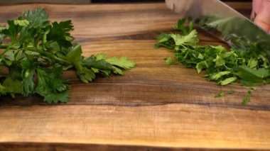 Aşçı ağaç kesme tahtasıyla maydanoz kesiyor..