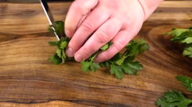 Aşçı ağaç kesme tahtasıyla maydanoz kesiyor..