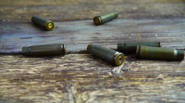 Mermi kovanları eski ahşap zemine yakın çekim yapıyor. Yavaş çekim.