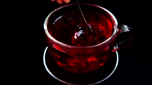 Hibiszkusz tea elkészítése üvegpohárban.