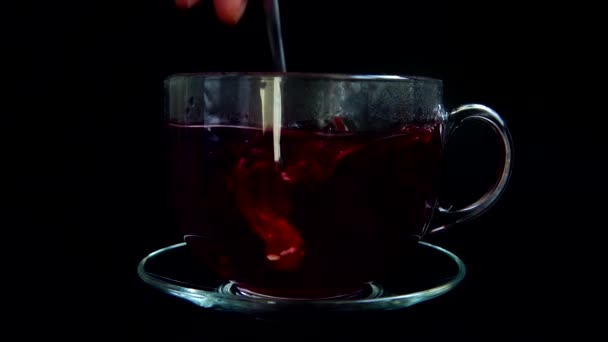 Hibiszkusz tea elkészítése üvegpohárban.