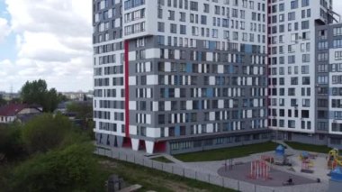 Modern konut binasının üzerinde uçan bir dron görüntüsü.