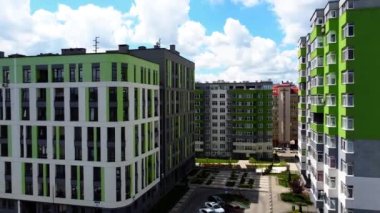 Modern konut binasının üzerinde uçan bir dron görüntüsü.