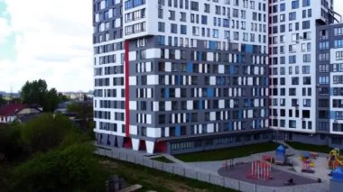 Modern konut binasının üzerinde uçan bir dron görüntüsü.