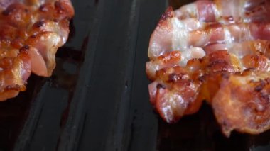 Kızarmış pastırma dilimleri ızgara tavasında döner..