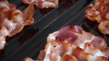 Kızarmış pastırma dilimleri ızgara tavasında döner..