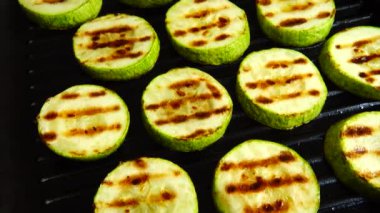 Kızarmış kabak dilimleri ızgara tavasında döner..