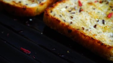 Zeytinyağı ve baharatlı ekmek tostu ızgara tavasında döner..