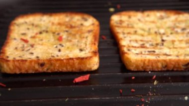 Zeytinyağı ve baharatlı ekmek tostu ızgara tavasında döner..