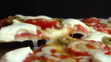 Mozzarella peynirli, zeytinli, domatesli ve salamlı pizza..