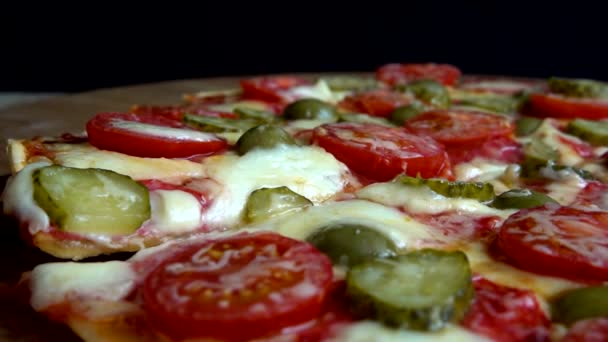 Krájená pizza se sýrem mozzarella, olivami, nakládanými okurkami, rajčaty a salámem.