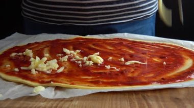 Domates soslu ve mozzarella peynirli pizza pişirmek. Rendelenmiş peynir.