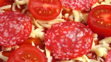 Mozzarella peynirli, domatesli, domates soslu ve salamlı pizza..
