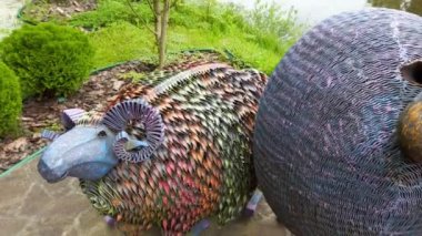 Orman gölünün arka planında bahçedeki metal dekoratif koyunlar..