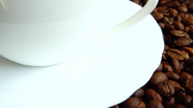 Kahve çekirdeğinin arka planında kahve fincanı..