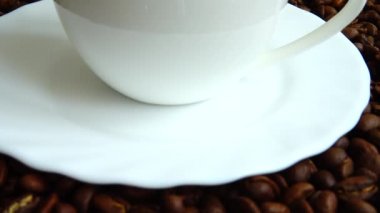 Kahve çekirdeğinin arka planında kahve fincanı..