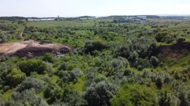 Kırsal tarım alanları arasındaki teknojenik arazi üzerinde uçan bir hava aracı görüntüsü.