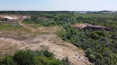 Kırsal tarım alanları arasındaki teknojenik arazi üzerinde uçan bir hava aracı görüntüsü.