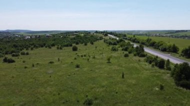 Kırsal tarım arazisinin üzerinde uçan bir dron görüntüsü.