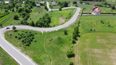 Kırsal tarım arazisinin üzerinde uçan bir dron görüntüsü.