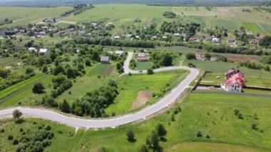 Kırsal tarım arazisinin üzerinde uçan bir dron görüntüsü.