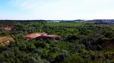Kırsal tarım alanları arasındaki teknojenik arazi üzerinde uçan bir hava aracı görüntüsü.