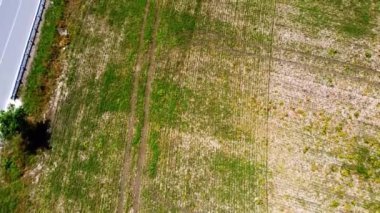Kırsal tarım arazisinin üzerinde uçan bir dron görüntüsü.