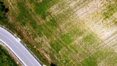 Kırsal tarım arazisinin üzerinde uçan bir dron görüntüsü.