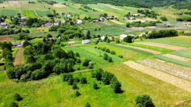 Kırsal tarım arazisinin üzerinde uçan bir dron görüntüsü.