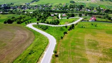 Kırsal tarım arazisinin üzerinde uçan bir dron görüntüsü.