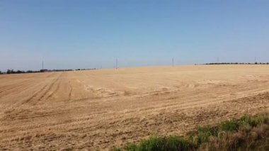 Kırsal tarım arazisinin üzerinde uçan bir dron görüntüsü.