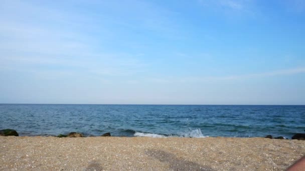 男は空と海を背景に砂を投げつける スローモーション — ストック動画
