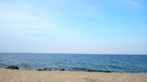 男は空と海を背景に砂を投げつける スローモーション — ストック動画