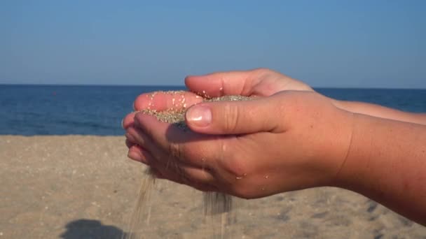 Άμμος Πέφτει Από Χέρι Της Γυναίκας Στο Φόντο Της Θάλασσας — Αρχείο Βίντεο