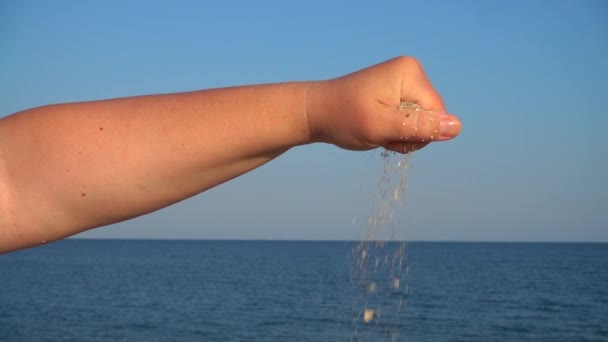 Άμμος Πέφτει Από Χέρι Της Γυναίκας Στο Φόντο Της Θάλασσας — Αρχείο Βίντεο