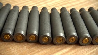 Tahta bir arka plandaki makineli tüfekten çıkan mermi kovanı..