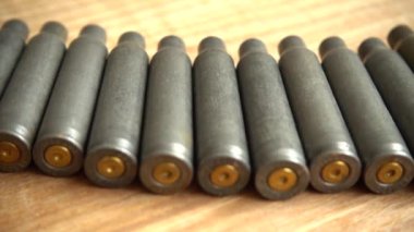 Tahta bir arka plandaki makineli tüfekten çıkan mermi kovanı..