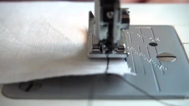 Dikiş makinesi kumaş ve iplikle, yakın çekim.