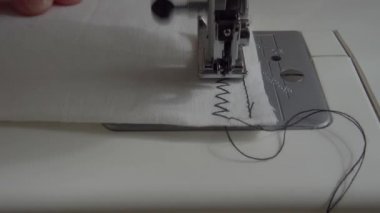 Dikiş makinesi kumaş ve iplikle, yakın çekim.