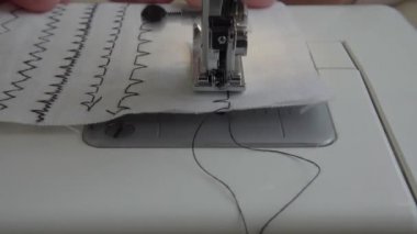 Dikiş makinesi kumaş ve iplikle, yakın çekim.