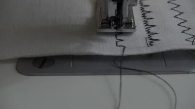 Dikiş makinesi kumaş ve iplikle, yakın çekim.