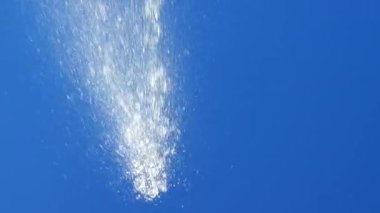 Çeşmenin püskürtüleri gökyüzüne karşı. Yansıma.