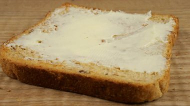 Bir dilim kızarmış ekmeğe kırmızı frenk üzümü reçeli ve tereyağı sür..