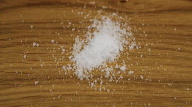 Doğal deniz tuzunun ince kristalleri ahşap bir yüzeye düşer. Büyük bir tuz yığını, bolca tuz. Yavaş çekim.