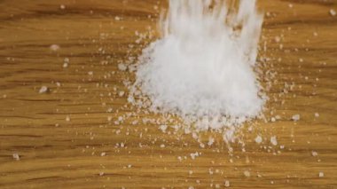 Doğal deniz tuzunun ince kristalleri ahşap bir yüzeye düşer. Büyük bir tuz yığını, bolca tuz..