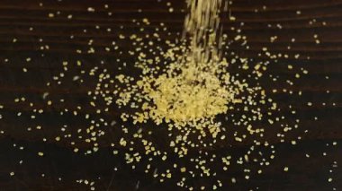 Kahverengi şeker kristalleri koyu kahverengi ahşap bir yüzeye serpilmiştir..