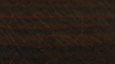 Kahverengi şeker kristalleri koyu kahverengi ahşap bir yüzeye serpiştirilir. Bir yığın şeker, bir sürü şeker..