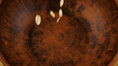 Yulaf ezmesi, ahşap bir tahtaya karşı terakotta kil kasesine dökülür. Üst görünüm.